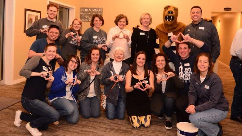 group of adult making THON triangle shape with their hands